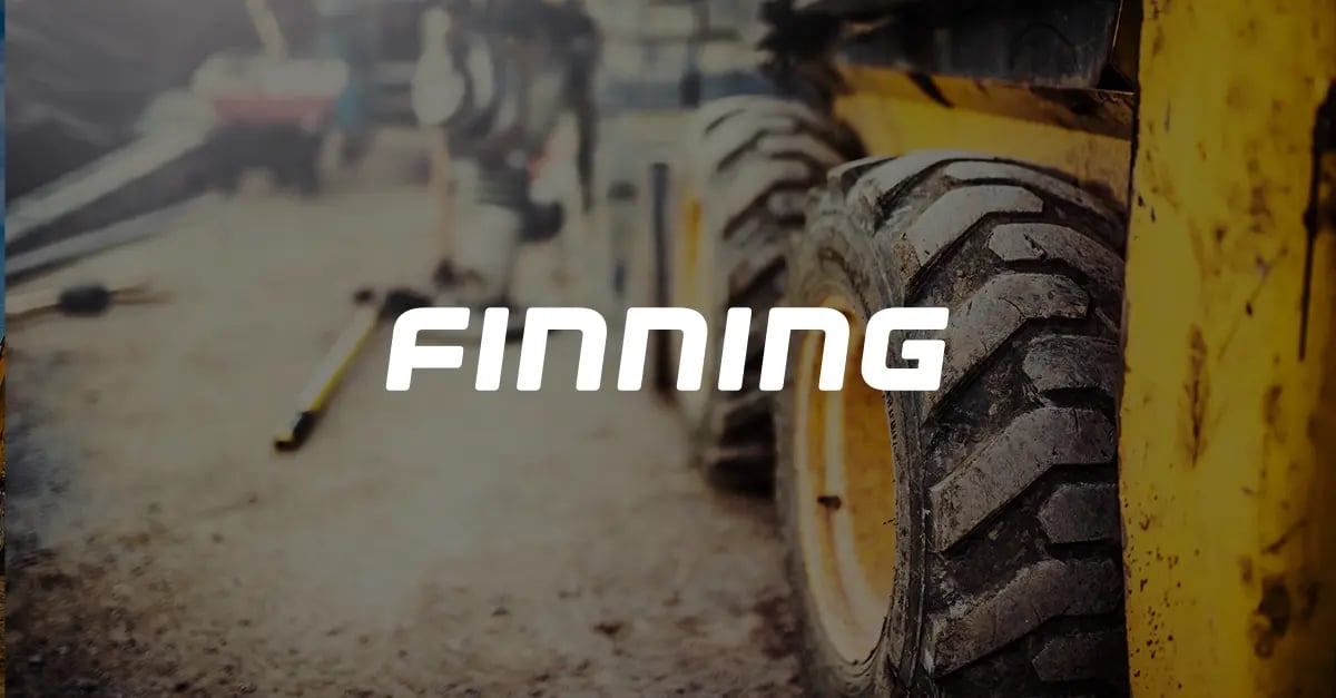 A photo of a bulldozer or excavator on a construction site with a white Finning logo in the middle